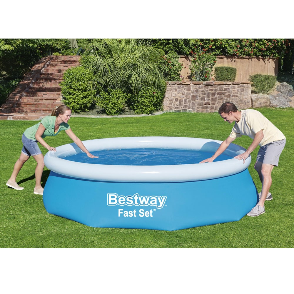 Zwei Menschen legen die Bestway Solarfolie für 305cm Pools Nettomaß Ø 289cm auf das Poolwasser