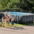 Kinder und eine Frau stehen vor dem Intex Rectangular Pool 26356 – 549x274x132 cm Set inkl. Sandfilter