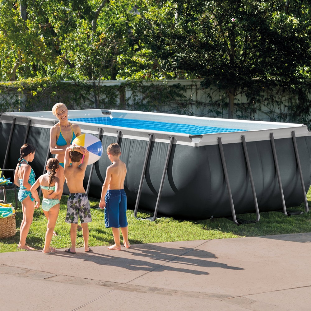 Kinder und eine Frau stehen vor dem Intex Ultra Frame Pool 549x274x132 cm Set inkl. Sandfilteranlage 26356