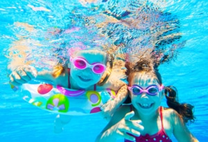 Kinder tauchen im Poolwasser unter