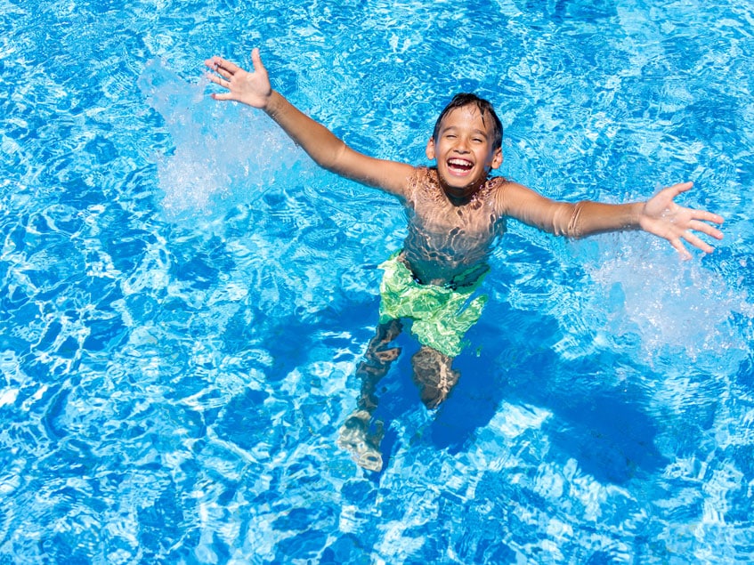 Kind freut sich im Poolwasser und lacht