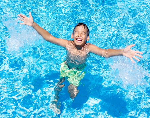 Kind freut sich im Poolwasser und lacht