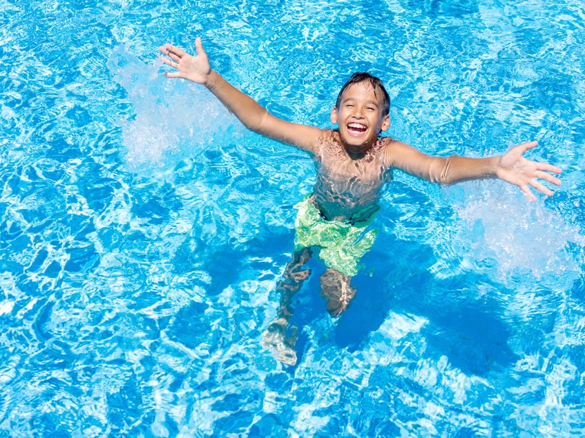 Kind lacht und freut sich im Poolwasser
