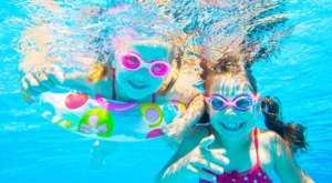 Kinder spielen im Poolwasser und lachen
