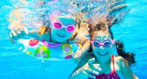 Kinder spielen unter Wasser im Pool