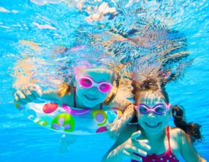 Kinder tauchen im Poolwasser ab