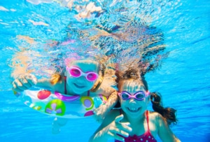Kinder unter Wasser im Pool