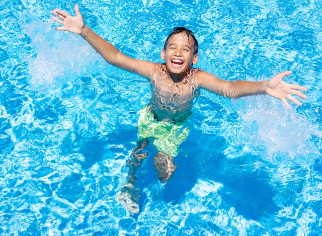 Kind lacht und freut sich im Poolwasser