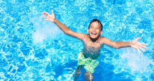 Kind freut sich und lacht im Poolwasser