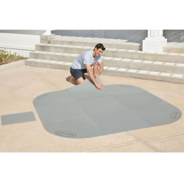 Mann legt die Bestway LAY-Z-SPA® Bodenschutzfliesen-Set, 216 x 216 cm auf dem Boden aus