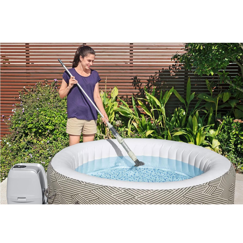 Frau reinigt den Whirlpoolboden mit dem Bestway® LAY-Z-SPA® Xtras Akku - Pool- & Spa-Sauger 150 x 16,8 x 9,6 cm