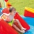 Kind rutscht auf dem Intex Rainbow Ring Play Center - Kinder Planschbecken 297 x 193 x 135 cm