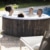 Familie entspannt sich im LAY-Z-SPA® Bahamas AirJet™ Whirlpool, 180 x 66 cm, 2-4 Personen, rund, Holz-Optik