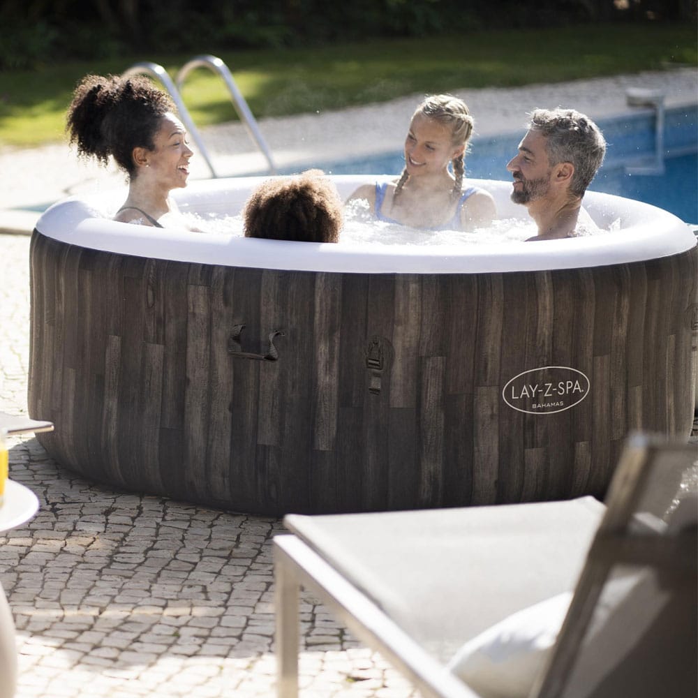 Familie entspannt sich im LAY-Z-SPA® Bahamas AirJet™ Whirlpool, 180 x 66 cm, 2-4 Personen, rund, Holz-Optik