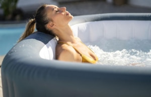 Frau entspannt sich im LAY-Z-SPA® Hawaii HydroJet Pro™ Whirlpool, 180 x 180 x 71 cm, 4-6 Personen, eckig, grau