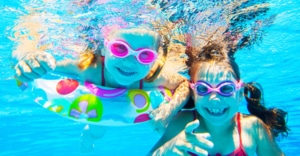 Kinder freuen sich im Poolwasser