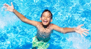 Kind freut sich und lacht im Poolwasser