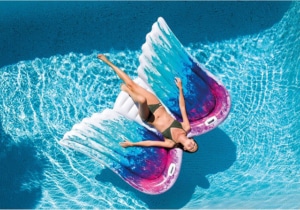 Frau lässt sich auf ihrer Intex Luftmatratze mit Engelsflügeln auf dem Pool treiben