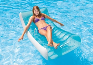 Frau lässt sich auf ihrer Intex Luftmatratze Rockin Lounge durch den Pool treiben