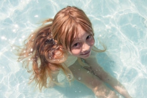 Kind sitzt in Pool mit weniger Wasser