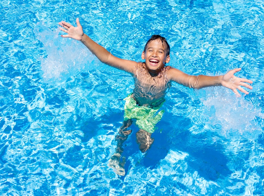 Kind freut sich im Poolwasser und lacht